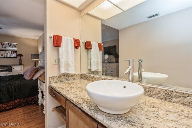 bathroom featuring visible vents, wood finished floors, connected bathroom, and vanity