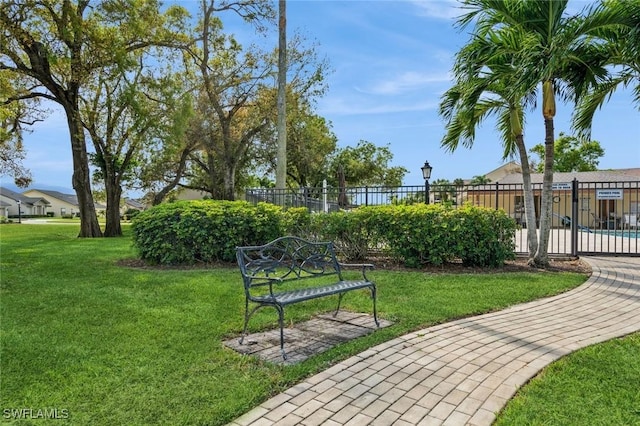 view of property's community featuring fence and a lawn