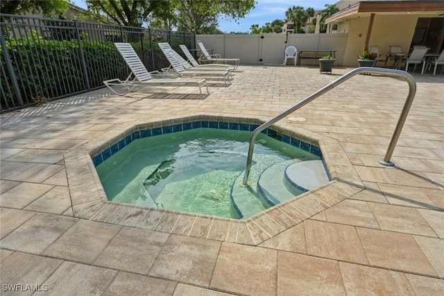view of pool featuring a patio, a community hot tub, and fence