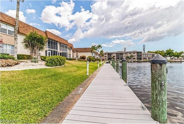 view of dock featuring a yard and a water view