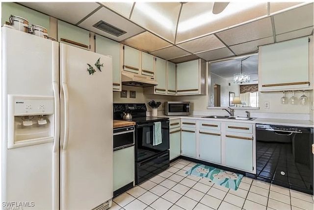 kitchen featuring pendant lighting, black appliances, white cabinetry, sink, and light tile patterned floors