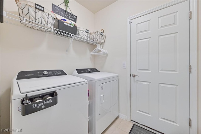 laundry area featuring light tile patterned floors and washer and clothes dryer