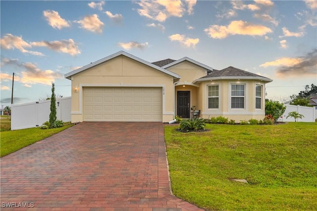 single story home featuring a garage and a front lawn