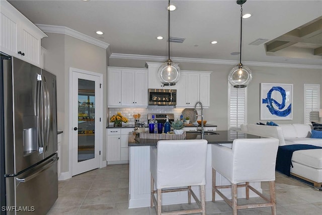 kitchen with stainless steel appliances, white cabinetry, and a center island with sink