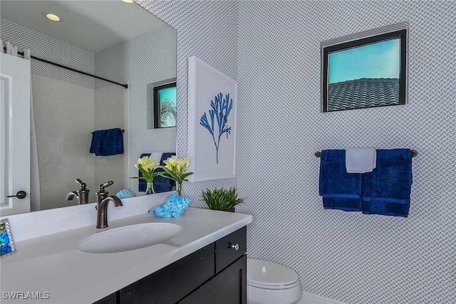 bathroom featuring toilet, vanity, and walk in shower