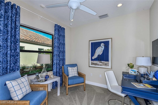 carpeted office space featuring ceiling fan