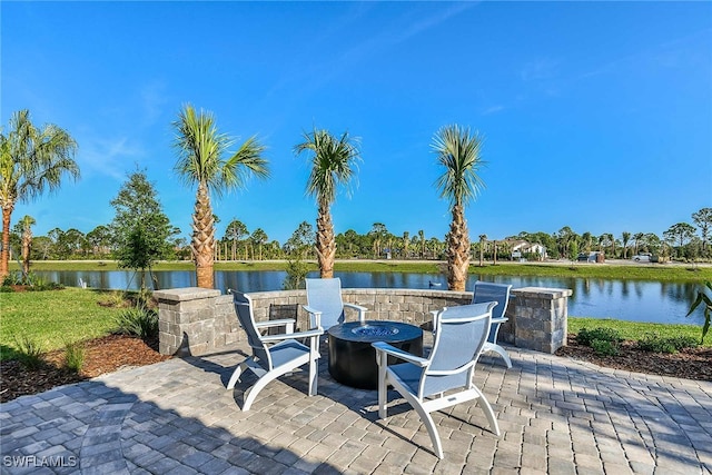 view of patio / terrace featuring an outdoor fire pit and a water view