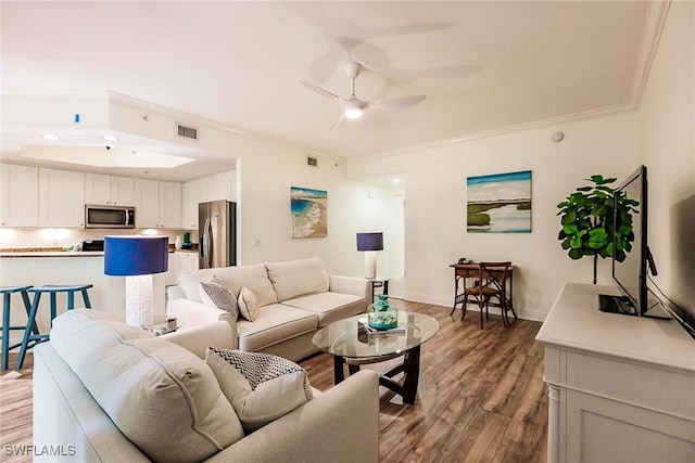 living room featuring hardwood / wood-style flooring, crown molding, and ceiling fan