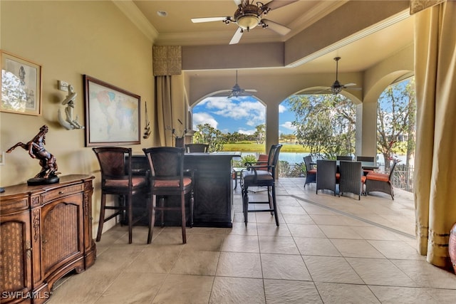 view of patio with ceiling fan, outdoor dining area, and a water view