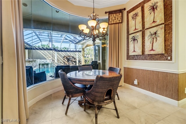 dining room featuring a wainscoted wall, a sunroom, an inviting chandelier, tile patterned flooring, and wood walls