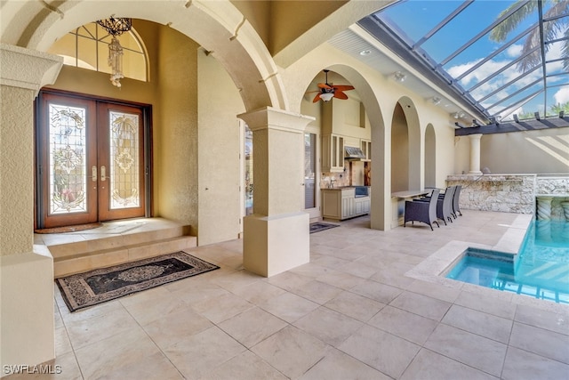 entrance to property with a patio, french doors, an outdoor kitchen, and stucco siding