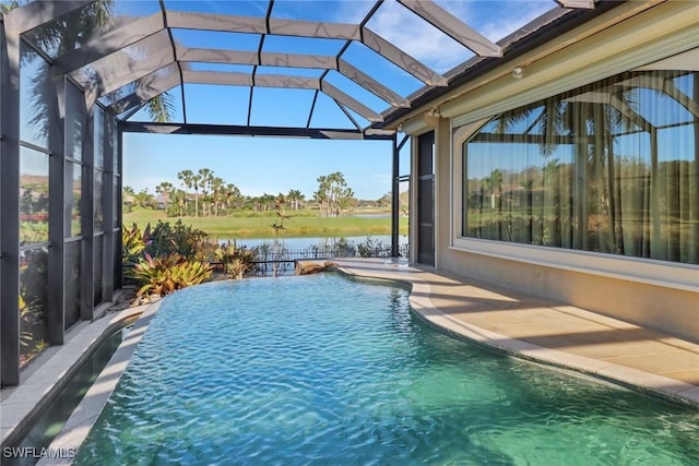 outdoor pool featuring glass enclosure, a patio, and a water view