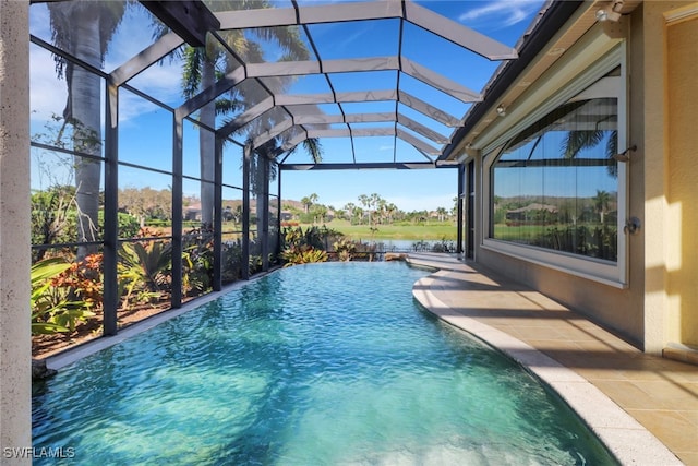 view of pool with glass enclosure, a patio area, and an infinity pool