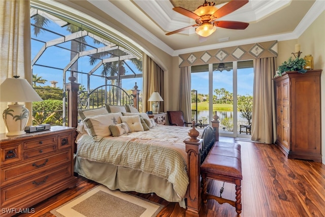 bedroom featuring wood finished floors, a sunroom, access to exterior, a tray ceiling, and crown molding