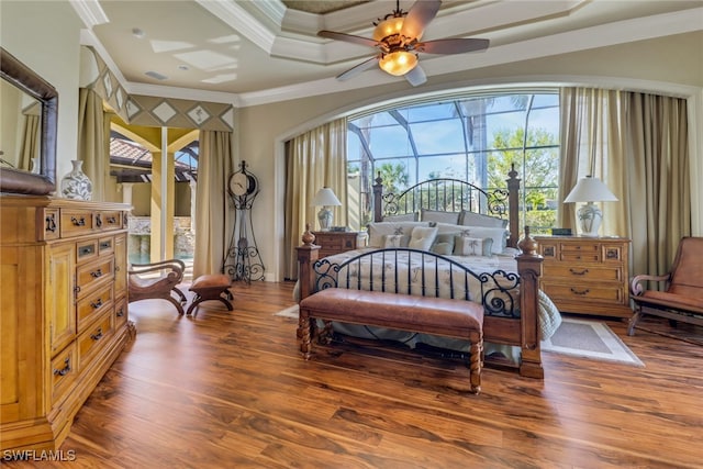 bedroom featuring a ceiling fan, a sunroom, crown molding, and wood finished floors