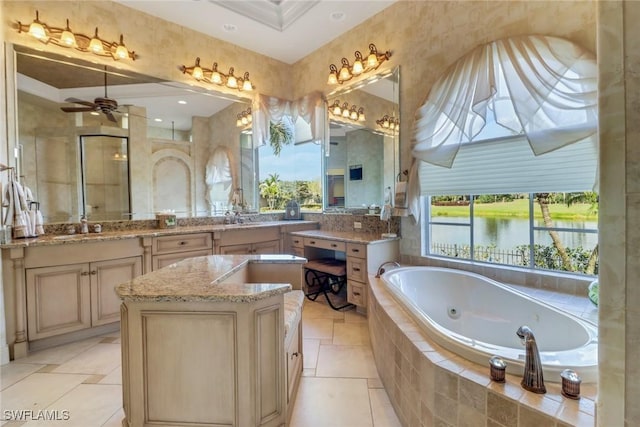 full bathroom with double vanity, a water view, a ceiling fan, a sink, and a jetted tub