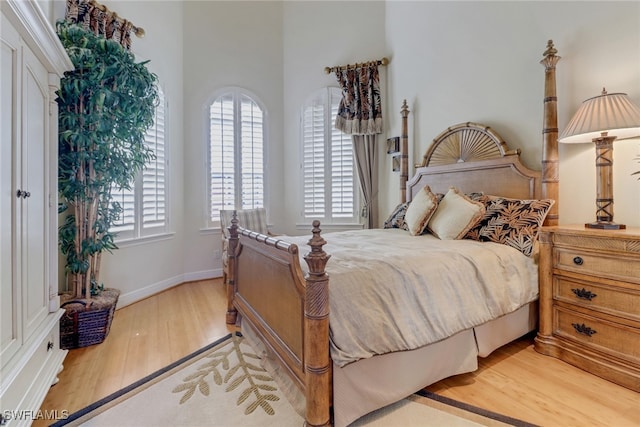 bedroom with light wood-type flooring and baseboards