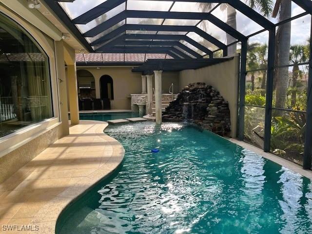 pool with glass enclosure and a patio