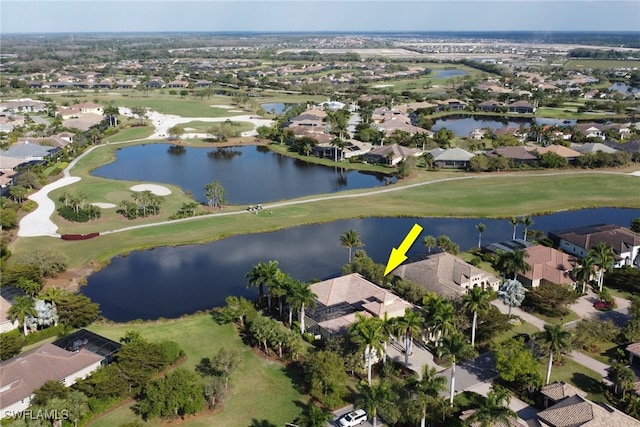 drone / aerial view featuring a residential view, view of golf course, and a water view