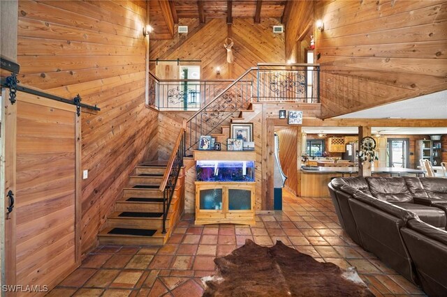 unfurnished living room with a barn door and wood walls