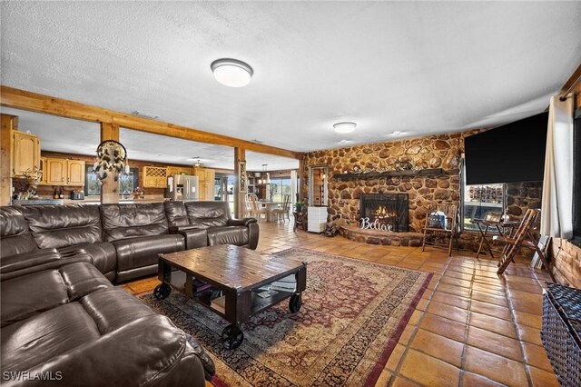 tiled living room featuring a fireplace and a textured ceiling