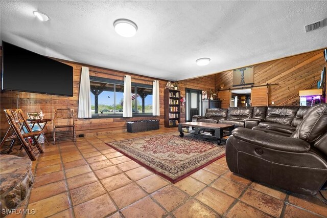 living room featuring vaulted ceiling, a textured ceiling, and wooden walls