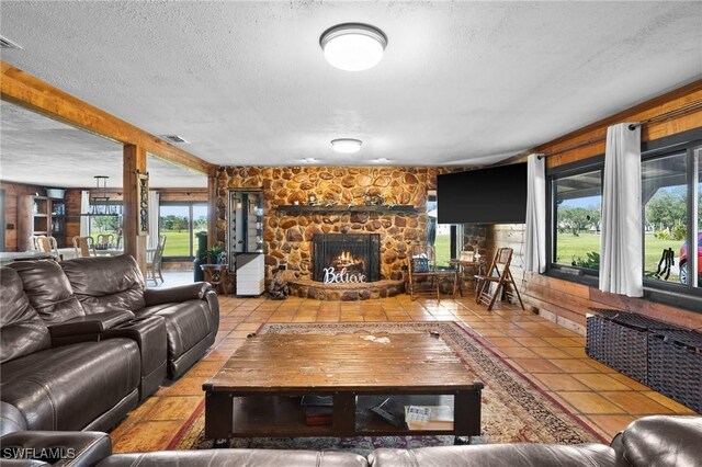 living room with tile patterned flooring, a fireplace, and a textured ceiling