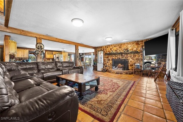 living room with a healthy amount of sunlight, a fireplace, a textured ceiling, and light tile patterned floors