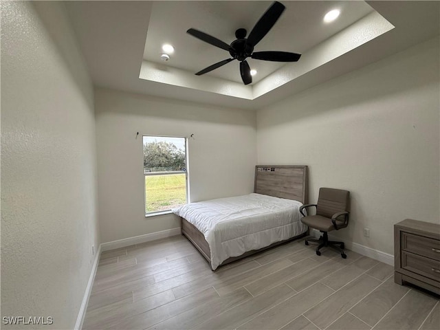 bedroom featuring ceiling fan and a raised ceiling