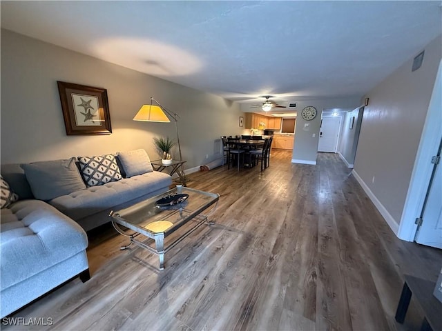 living room featuring hardwood / wood-style floors and ceiling fan