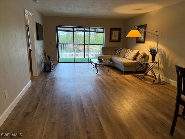 living room with dark wood-type flooring and a textured ceiling