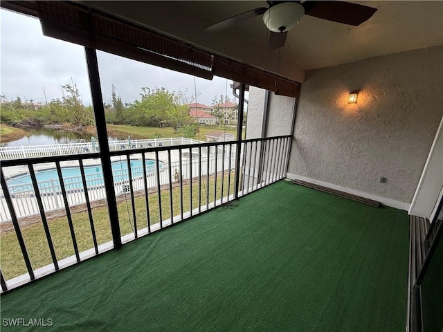 balcony featuring ceiling fan and a water view