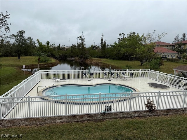 view of swimming pool featuring a patio, a water view, and a lawn