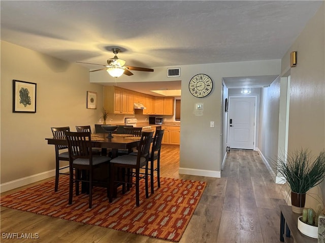 dining room featuring dark wood-type flooring, baseboards, and visible vents