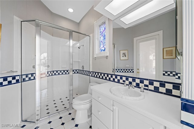 bathroom featuring toilet, a shower with shower door, tile patterned flooring, vanity, and lofted ceiling