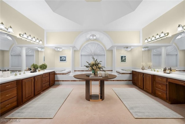 bathroom with decorative columns, a bathtub, and vanity