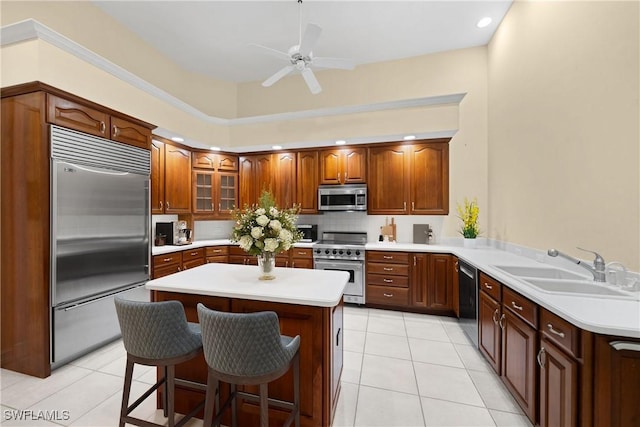 kitchen featuring a kitchen breakfast bar, kitchen peninsula, sink, light tile patterned floors, and high end appliances