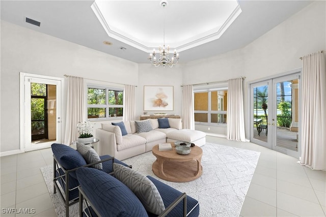 living room featuring a wealth of natural light, a raised ceiling, and light tile patterned floors