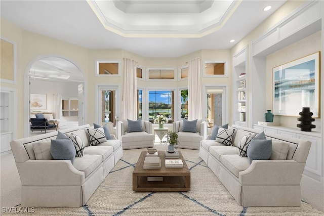 carpeted living room with ornamental molding, built in features, and a raised ceiling