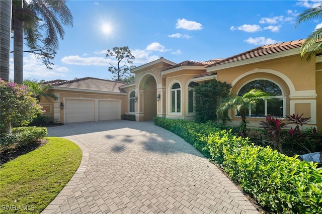 mediterranean / spanish-style home with a garage