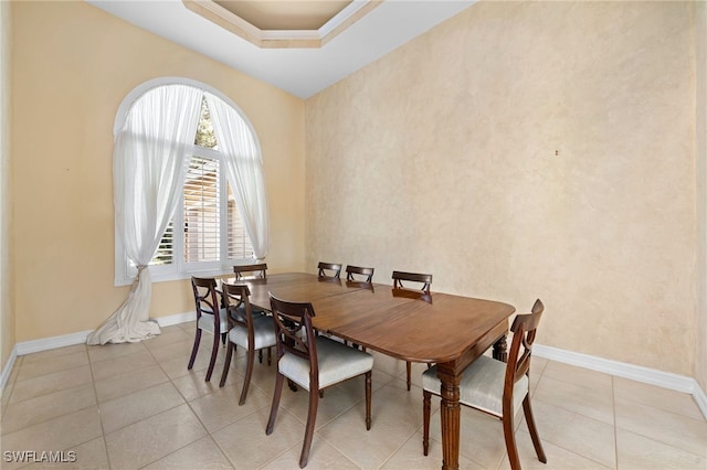 dining area featuring light tile patterned floors and a tray ceiling