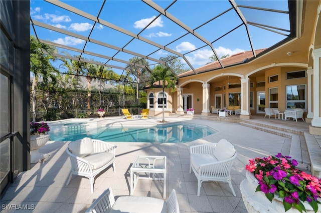 view of swimming pool featuring a lanai, a patio area, and ceiling fan