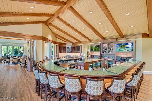 dining area featuring light hardwood / wood-style floors, beamed ceiling, high vaulted ceiling, and wood ceiling