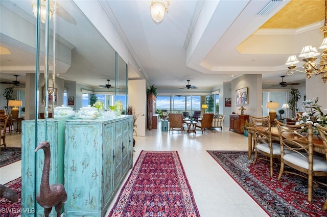 interior space with ornamental molding, a tray ceiling, visible vents, and tile patterned floors