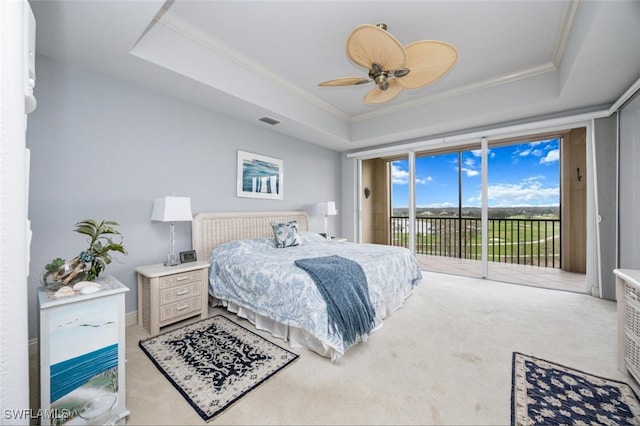 bedroom featuring access to exterior, a tray ceiling, carpet flooring, and crown molding