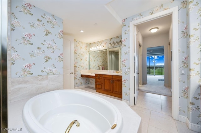 full bathroom with tile patterned flooring, a garden tub, vanity, and wallpapered walls