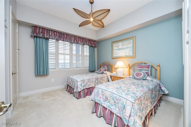 carpeted bedroom with ceiling fan and baseboards