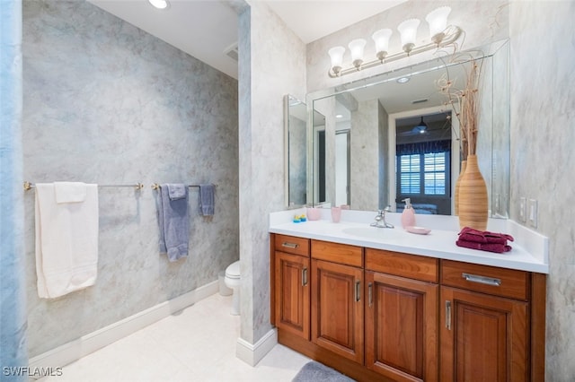 bathroom featuring toilet, tile patterned flooring, baseboards, and vanity