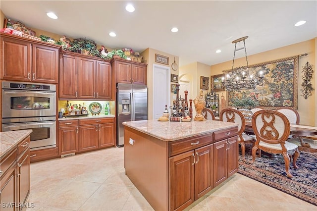 kitchen featuring light tile patterned floors, stainless steel appliances, light stone countertops, a kitchen island, and decorative light fixtures