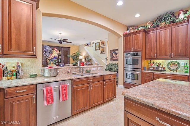 kitchen with sink, backsplash, light tile patterned floors, and appliances with stainless steel finishes